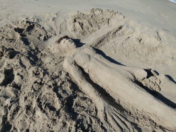A sand person left on the beach