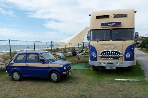 The small car, colour co-ordinated drives into the back. It is a converted delivery truck and is 49 years old. the owner did the conversion. Inside it is divided into an upper and lower level.