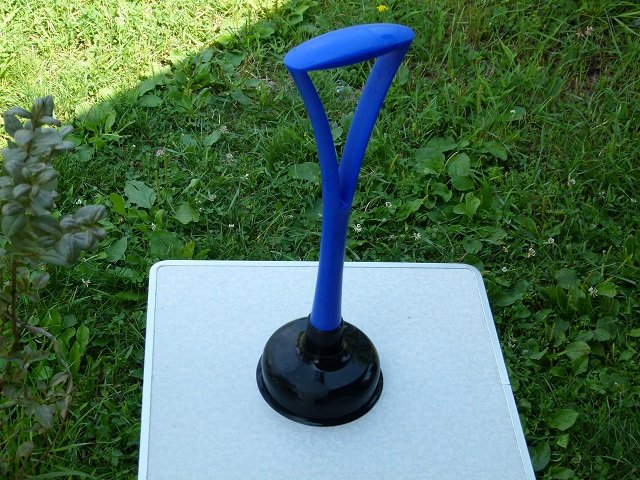 This plumbers plunger fits into the plastic tub and by moving it up and down agitates to clothes in the water.